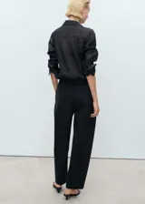 Pantalón de corte recto y tiro medio color negro, con cintura elástica y bolsillos laterales.