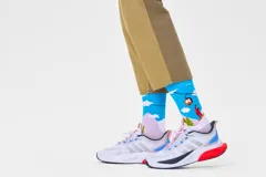 Medias Happy Socks con diseño de snowboarders, árboles y teleférico sobre fondo celeste y lila.