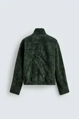 Cazadora regular fit de piel con acabado en ante color verde oscuro, de la colección especial Gabriel Azevedo x ZARA. Cuenta con cuello subido, manga larga, bolsillos de vivo en la cadera, bolsillo interior y bajo acabado con elástico. Cierre frontal con cremallera oculta por solapa con botones a presión.