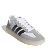 Championes Adidas Barreda Decode de estilo retro, con diseño inspirado en el calzado de fútbol. Presentan una combinación de paneles de tela blanca, refuerzos de gamuza gris en la puntera y el talón, y las icónicas tres tiras laterales en color negro. Cuentan con una mediasuela translúcida y suela de goma para mayor tracción.