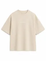 Remera de algodón pesado color beige, con diseño boxy, mangas cortas amplias y cuello redondo ribeteado. Cuenta con un pequeño estampado tipográfico en el pecho con la inscripción "BOHEMIANDESIGN®".