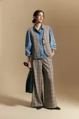 Pantalón de tiro alto con diseño a cuadros, corte wide leg y silueta amplia de caída fluida.