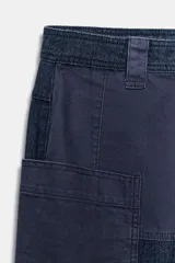 Pantalón worker de tiro medio de Zara Woman Collection, confeccionado en denim azul oscuro con detalles de combinación de tejidos a tono. Presenta cintura con trabillas, bolsillos laterales de plastrón, bajo acabado en vuelta y cierre frontal con cremallera y botón.