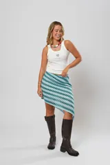 Minifalda asimétrica de crochet con diseño geométrico en tonos celeste, blanco y verde.