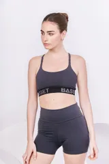 Top deportivo gris oscuro con espalda cruzada y elástico con logo "Asset Bass".