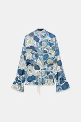 Camisa de manga larga ZARA Woman Collection con estampado floral en tonos azules y blancos, cuello redondo subido, bolsillos de plastrón en el delantero y cintura ajustable con cordones.