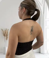 Body negro con escote halter y espalda descubierta, con pequeños apliques brillantes.