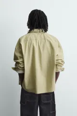 Camisa de corte boxy fit confeccionada en tejido de algodón con estampado de cuadros. Presenta cuello solapa, manga larga con puños abotonados, bolsillo plastrón en el pecho y cierre frontal de botones. Incluye un bordado a contraste en el pecho.