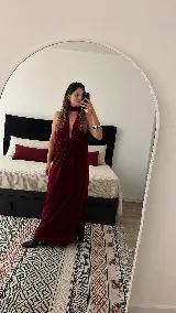 Vestido largo de terciopelo negro, con diseño al cuerpo, escote halter y pronunciado escote en V con frunce central.