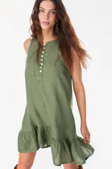 Vestido corto lila de lino, sin mangas, con escote redondo, cartera de botones de nácar en el frente y volado fruncido en el ruedo.