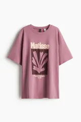 Remera oversized de algodón color rosado, de manga corta con hombros caídos y cuello redondo. Cuenta con un diseño estampado frontal inspirado en Matisse.