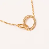 Colgante dorado con cadena fina y dos aros entrelazados como dije. Uno de los aros es liso y el otro está adornado con pequeñas piedras brillantes.