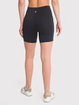 Calza corta deportiva negra de tiro alto, confeccionada en poliéster y spandex. Cuenta con banda de silicona para mayor sujeción, bolsillos laterales y certificación Bluesign.