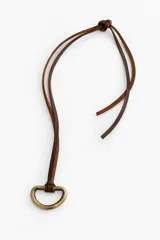 Collar de diseño artesanal con cordón de cuero marrón chocolate y pieza metálica en forma de medio aro con acabado en oro viejo.