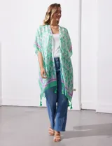 Kimono tejido con estampado abstracto en tonos azules, blancos y violetas. Tiene terminación de ruedo con borlas.