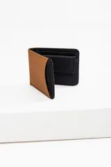 Billetera de cuero vegano color marrón y negro, con cuatro compartimentos y un monedero con cierre a presión.