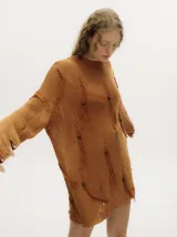 Sweater de punto semiabierto color naranja, con diseño holgado tipo vestido, detalles rasgados, flecos y canutillos de madera. Presenta bordados en crochet en cuello y puños, con pespuntes en hilo grueso en la sisa.