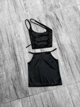 Top negro asimétrico con un solo tirante ancho y un corte en el pecho.