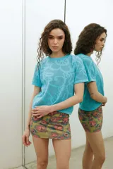 Remera de tejido de punto color celeste, de manga corta, con diseño calado en el frente.