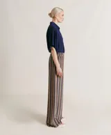 Pantalón de pierna ancha con estampado a rayas verticales en tonos verde, amarillo, morado y marrón.