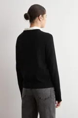 Sweater clásico de punto color beige, de cuello redondo y manga larga con diseño ajustado.