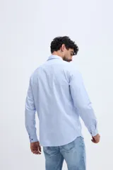 Camisa de manga larga fit semi slim color celeste, con cierre frontal de botones y cuello camisero clásico.