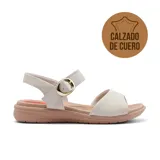 Sandalias bajas de cuero color blanco hueso, con tira ancha sobre el empeine y tira con hebilla dorada al tobillo. Suela color beige.