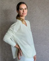 Sweater color crema de lana lambswool, con escote en V y corte holgado.