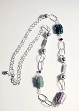 Collar largo de cadena de eslabones plateados con abalorios de piedras semipreciosas en tonos verde, gris y rosa, y cierre de mosquetón.