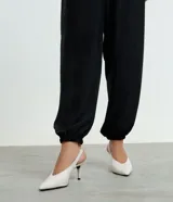 Zapato tipo slingback confeccionado en cuero legítimo, con diseño de punta fina, escote en V en el empeine y tacón fino de 8 cm. Presenta una tira elástica en el talón para mayor ajuste.