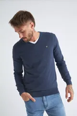 Sweater de tejido de punto color beige, con escote en V, mangas largas y puños y dobladillo acanalados. Presenta un pequeño logo bordado en el pecho.