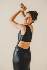 Vestido largo negro de fiesta, con un hombro descubierto, corte ajustado, drapeado lateral y tajo alto en la pierna.