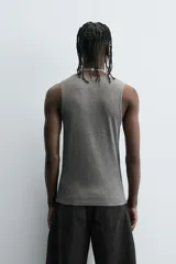 Camiseta sin mangas (tank top) negra, de corte slim fit, con cuello redondo de efecto doble.