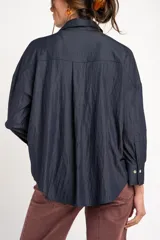 Camisa azul marino de manga larga, con cuello clásico, cierre frontal con botones y bolsillo aplicado en el pecho.