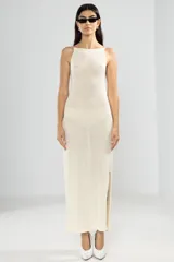 Vestido largo tejido color crema, con cuello halter y espalda baja.
