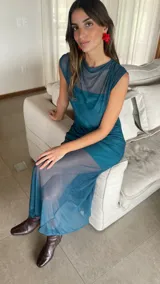 Vestido largo de microtul bordó, sin mangas, con escote alto tipo buche y diseño transparente con forro corto interno que genera un efecto translúcido en la falda.