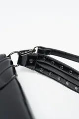 Bolso de mano tipo sobre color negro, confeccionado en cuero sintético, con solapa frontal decorada con tachas metálicas y correa larga ajustable y extraíble.