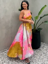 Vestido largo verde con diseño estampado tipo tie-dye y detalles dorados, de corte fluido, un solo hombro y diseño amplio.