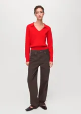 Jersey de punto fino color rojo, con cuello en V con solapa tipo polo y manga larga, de diseño recto.