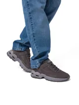 Championes Caterpillar modelo Surge Hiker Lo, color gris, de diseño robusto para trekking y uso urbano. Confeccionados en nubuck encerado y malla, cuentan con suela dentada de goma con tecnología SRX para mayor tracción y cordones redondos.