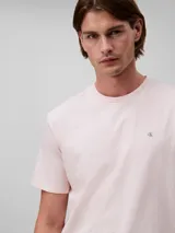 Remera de manga corta color rosado, confeccionada en algodón liso con cuello redondo. Presenta el monograma de Calvin Klein bordado en el pecho.
