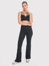 Calza negra de tiro alto, corte ajustado en la parte superior y acampanado en la parte inferior, con aberturas en los tobillos.