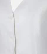 Chaleco de vestir color blanco hueso, con escote en V, cierre frontal con botones y espalda abierta. Corte sastrero.