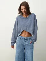 Buzo manga larga color celeste con diseño irregular y corte crop.