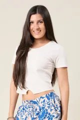 Remera básica de manga corta y cuello redondo, con diseño cropped y detalle de abertura central en el ruedo.