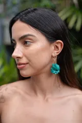 Aros colgantes con forma de flor color turquesa.