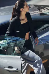 Saco sastrero corto a la cintura, color negro, con cierre frontal de un botón grabado, solapas clásicas, bolsillo ojal en el delantero, chapa metálica con logo en el pecho y bordado decorativo en la manga.