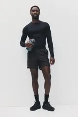 Short deportivo negro H&M en tejido funcional con tecnología DryMove™, de corte estándar, cintura elástica con cordón ajustable, bolsillos laterales y aberturas en el dobladillo.