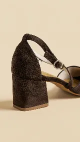 Zapato de tacón ancho de 5 cm, confeccionado en tela de tapicería resistente color negro. Presenta un diseño con escote en V y tiras cruzadas en diagonal con cierre de hebilla en el tobillo. Cuenta con forro y plantilla de cuero.