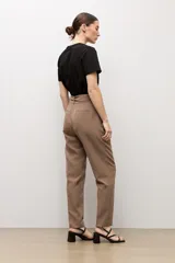 Pantalón sastrero color topo, de corte recto, con pinzas en la parte delantera y cinturón del mismo género con hebilla cuadrada.